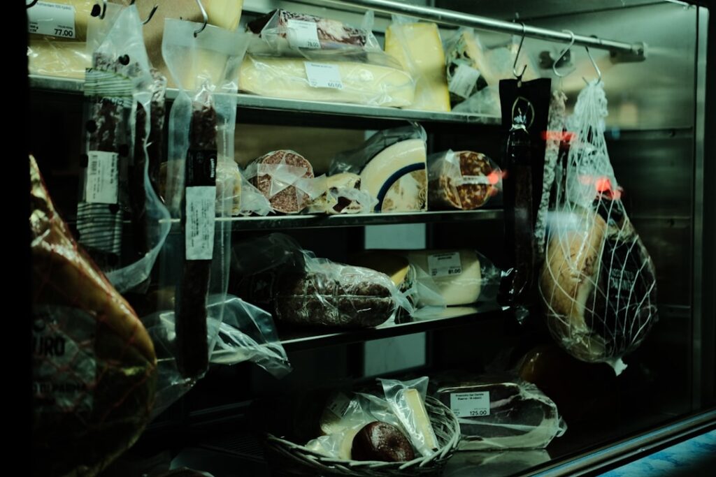 Charcuterie et fromages sous vide dans une vitrine du marché de Modène