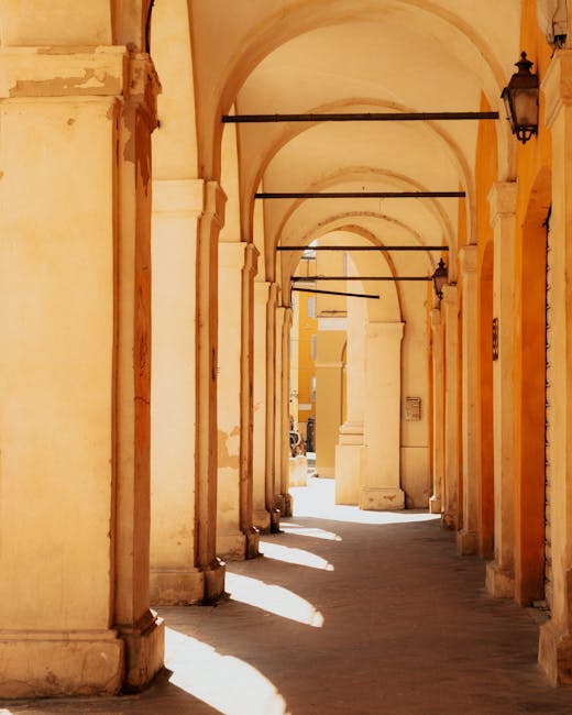 Sunlit arched portico with warm yellow plaster in Modena