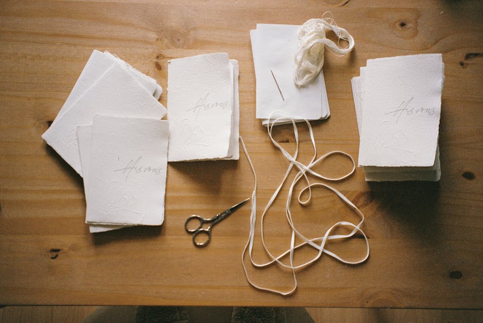 Modena papermaker's handmade cards, thread, and scissors on table
