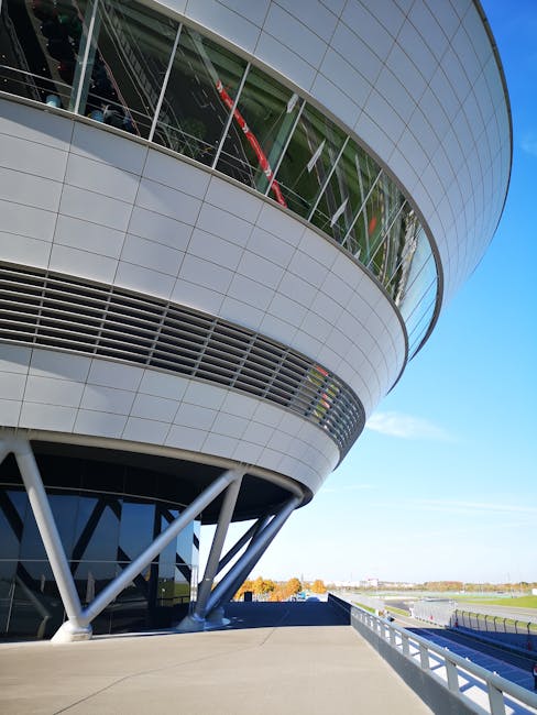 Rundes modernes Gebäude mit Metallfassade und sichtbaren Stahlstützen