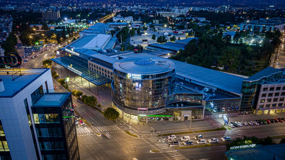 Aerial night view of illuminated circular shopping complex in Modena
