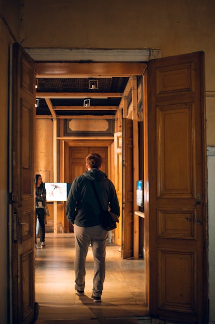 Korytarz Casa Museo z odwiedzającym spacerującym między drzwiami.