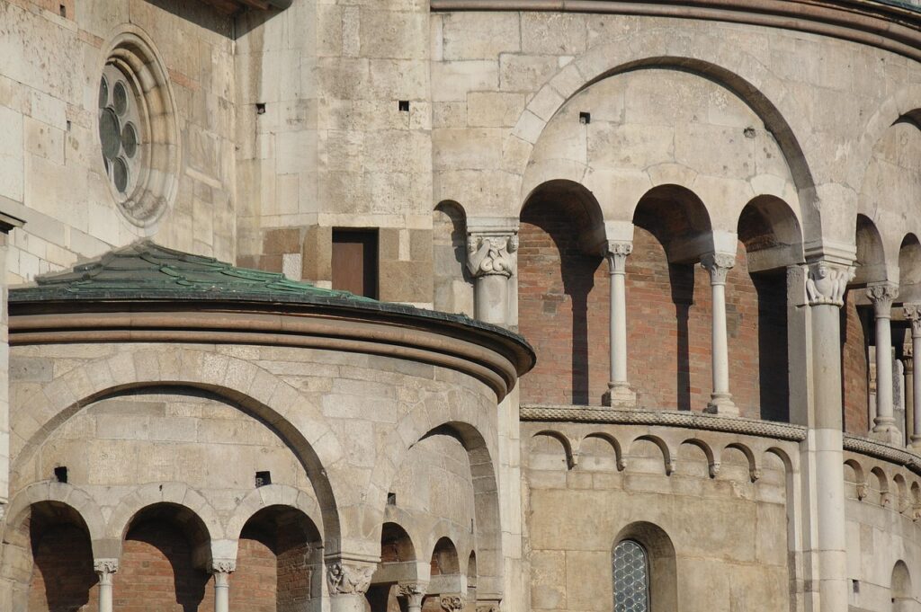 Romanesque stone arches and columns on Modena cathedral apse.