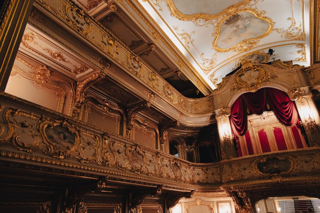Ornate gold-decorated theatre balconies with red velvet box in Modena