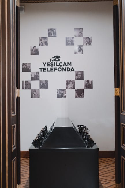 Row of black telephone headsets on display under 'YESILCAM TELEFONDA' wall signage.