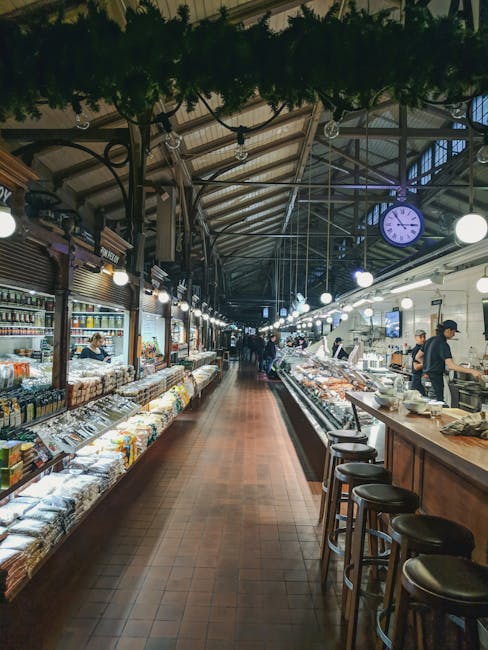 Lang marktpad met delicatessenstalletjes en klok in overdekte markt Modena