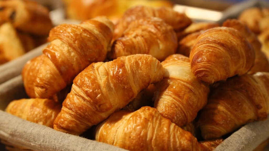 Versgebakken croissants in mand, gouden korst in een Modena-bakkerij