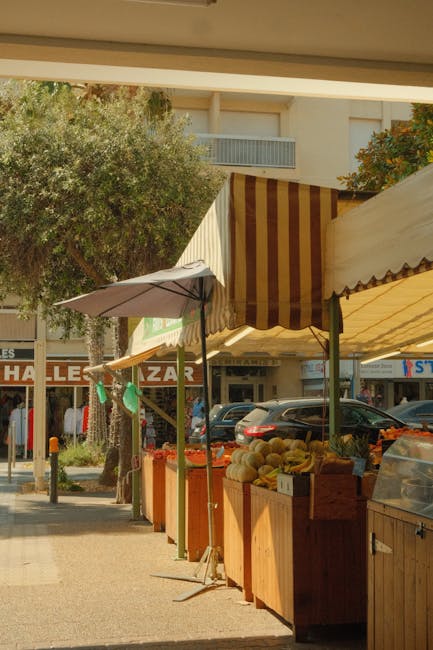 Corsia di bancarelle con tende a righe e frutta nel mercato di Modena