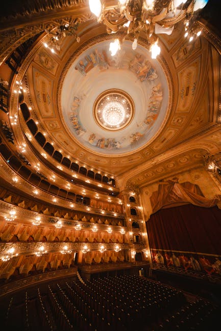 Historisch theaterinterieur in Modena met rijk versierde loges en kroonluchter.