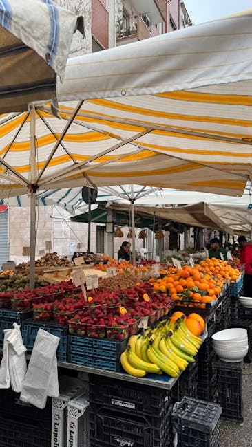 Straatmarkt in Modena met gestapelde aardbeien, bananen en sinaasappels.