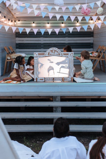 Bambini intenti a raccontare storie dietro un piccolo teatro delle ombre