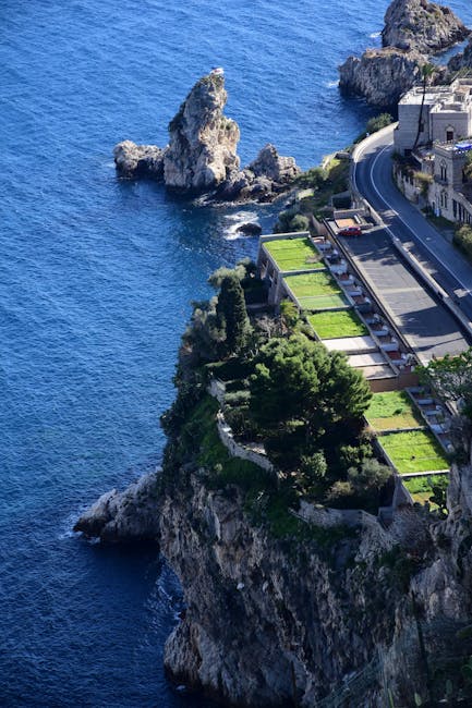 Steilklippe mit terrassierten Gärten und Straße über tiefblauem Meer auf Capri