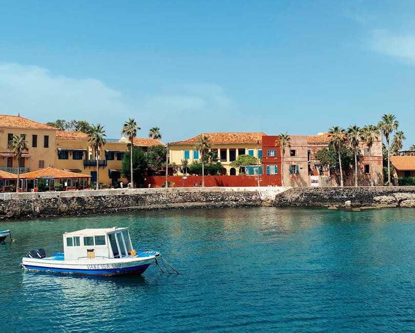 Petit bateau blanc ancré devant maisons colorées du port de Capri