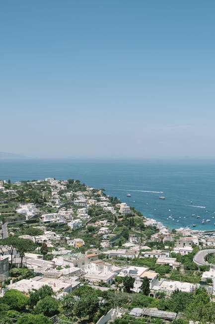 Uitzicht over terrassen en witte huizen op Capri richting zee