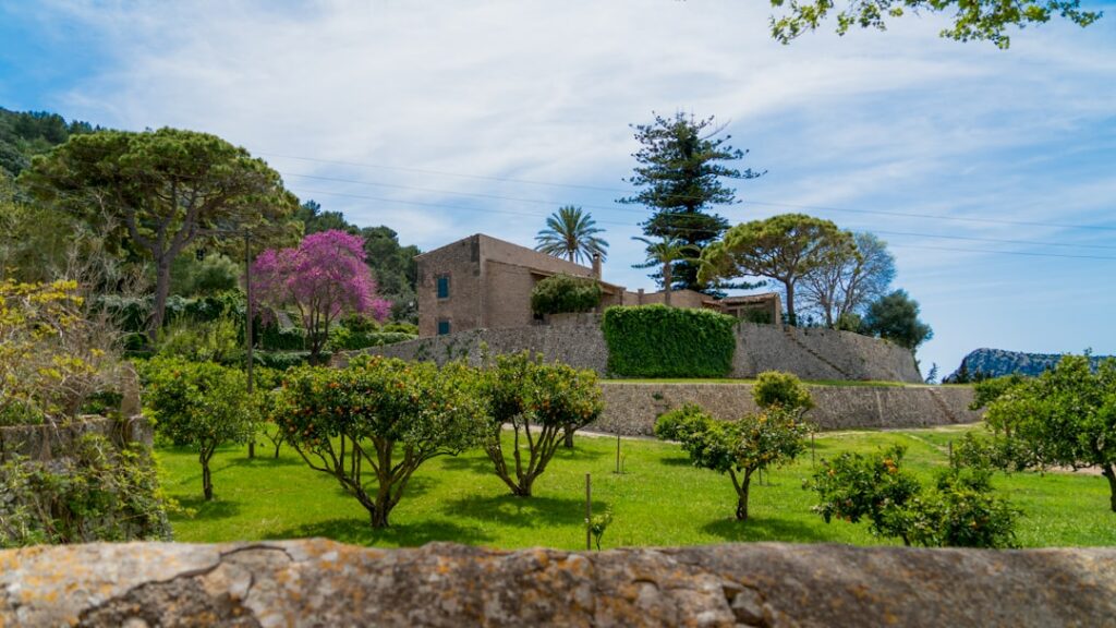 Steinfassade einer Villa mit Zitrusbäumen und grünem Rasen auf Capri