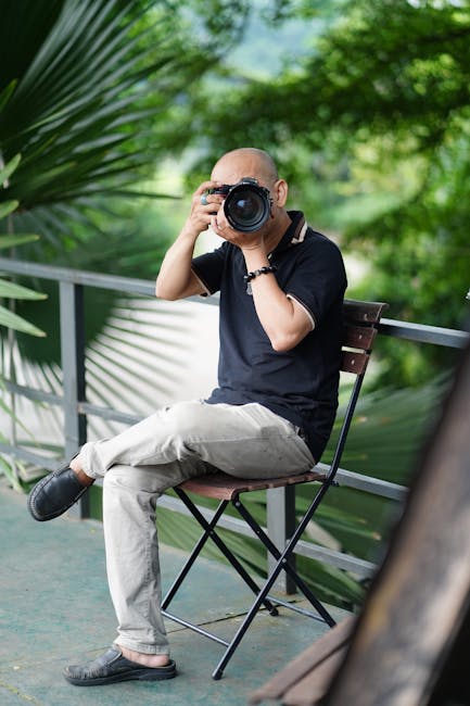 Personne assise tenant un appareil photo sur une terrasse verdoyante