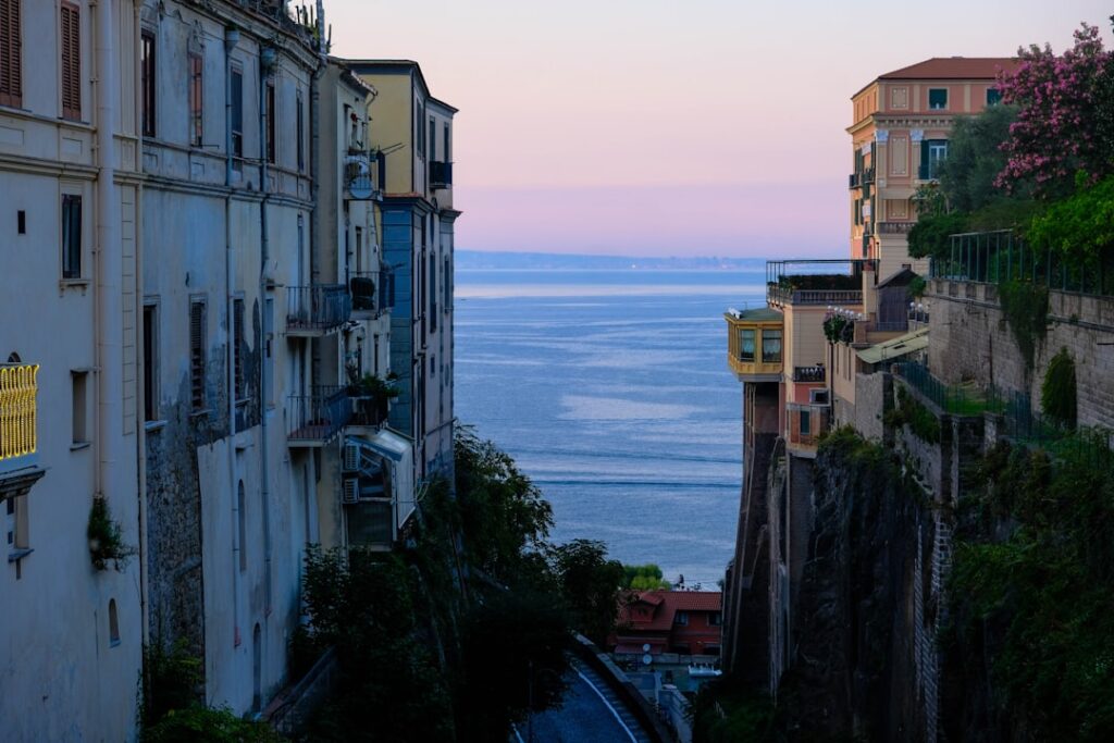 Sunset view down narrow Capri street opening to calm sea