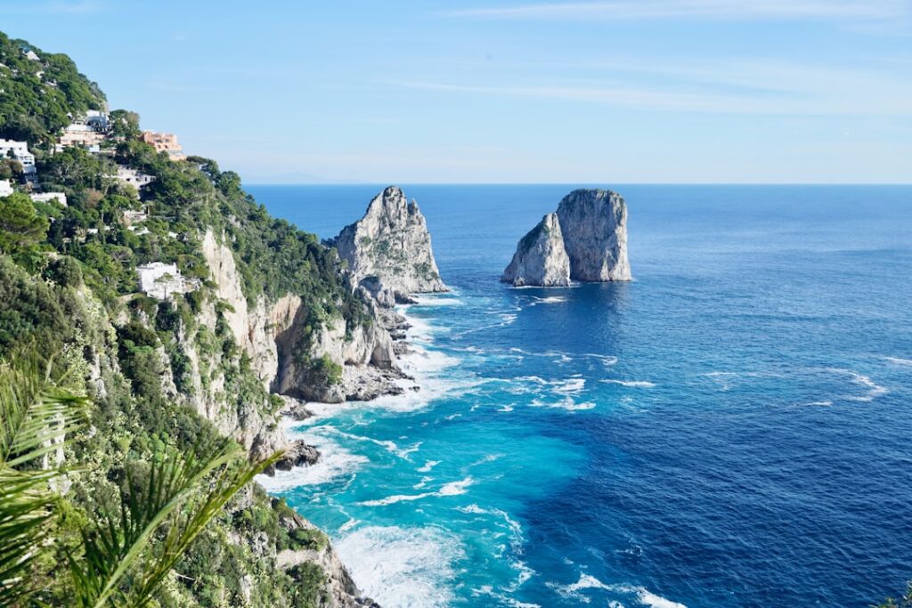 Turquoise waters and Faraglioni sea stacks off Capri's rocky coast