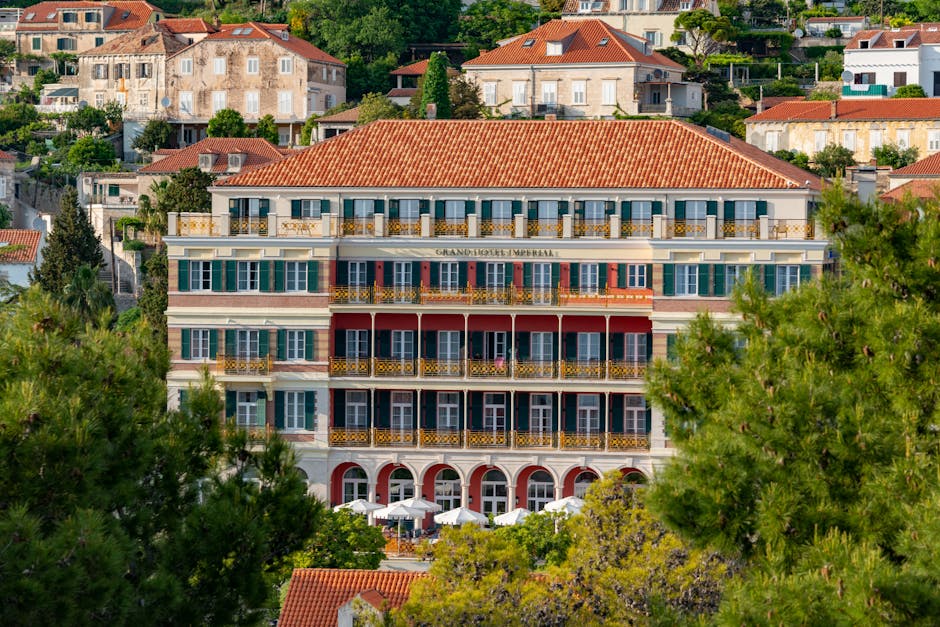 Elegante hotelgevel met balkons en groene luiken op Capri