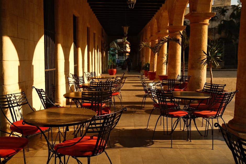 Leere Caféterrasse unter Arkaden mit roten Sitzkissen und warmem Licht auf Capri