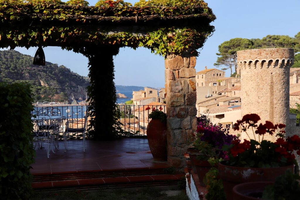 Terrazza pergolata con vasi di fiori e torre in pietra a Capri