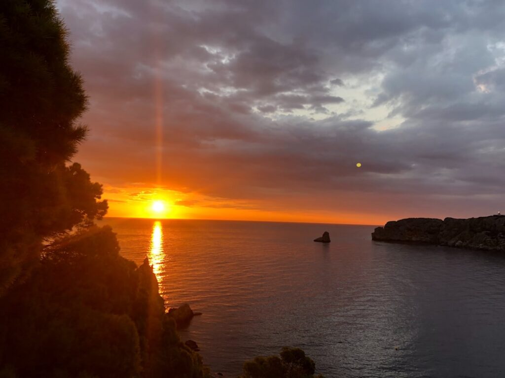 Sunset over Capri sea with glowing sun reflected on water