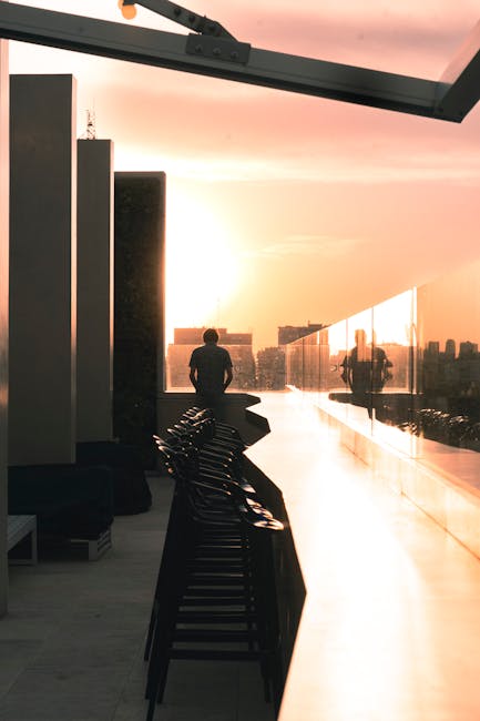 Capri rooftop bar at sunset with silhouetted person and chairs