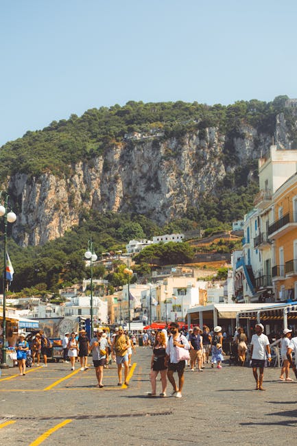 Crowded Capri waterfront promenade with tourists and steep limestone cliffs