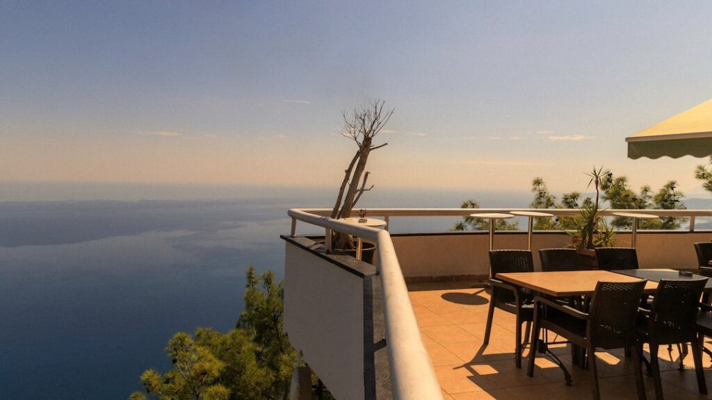 Terrasse ensoleillée à Capri avec tables et chaises, vue sur mer