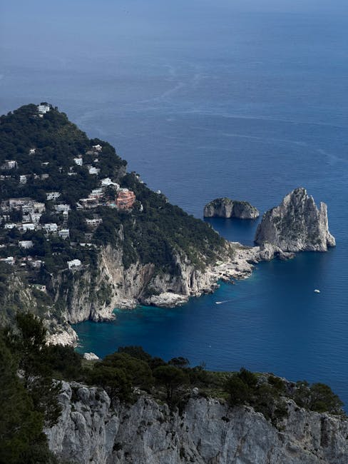 Blick auf Capris Klippen und Faraglioni-Felsen mit weißen Häusern