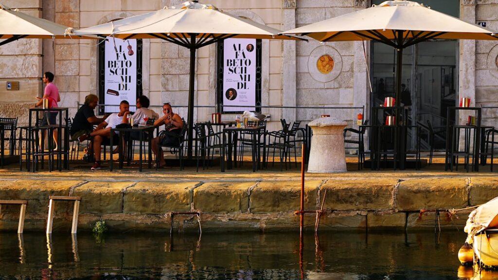 Terras met parasols en bezoekers aan de waterkant van Capri