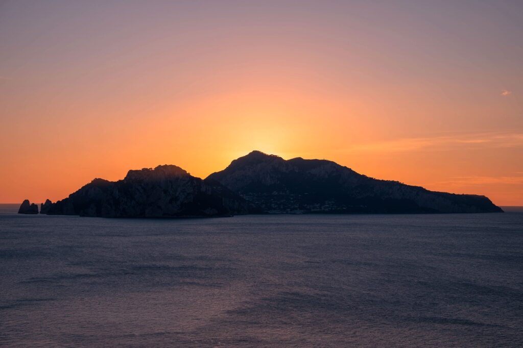 Zonsondergang achter het silhouet van het eiland Capri