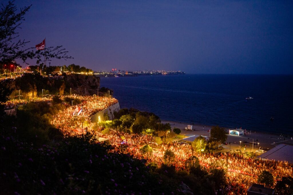 Nighttime cliff promenade illuminated with crowds along Capri coastline