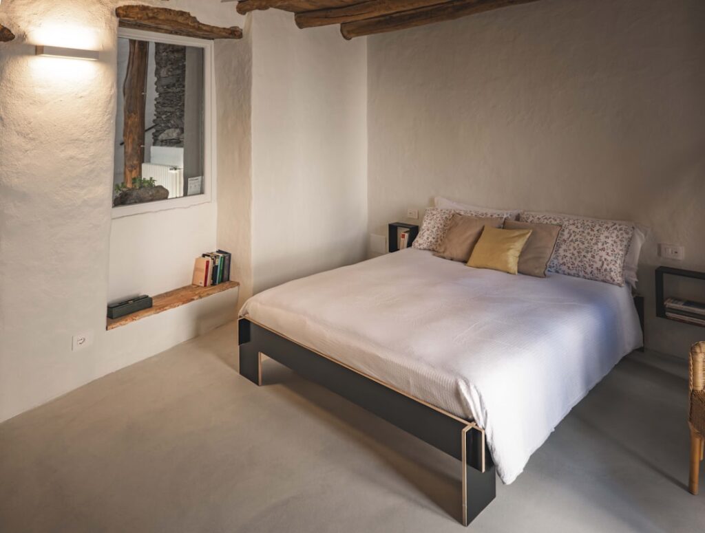 Cozy whitewashed bedroom with wooden beams in a Capri B&B