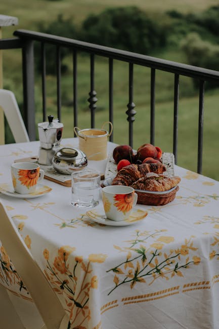 Ontbijttafel op balkon met croissants en kopjes, uitzicht op Capri