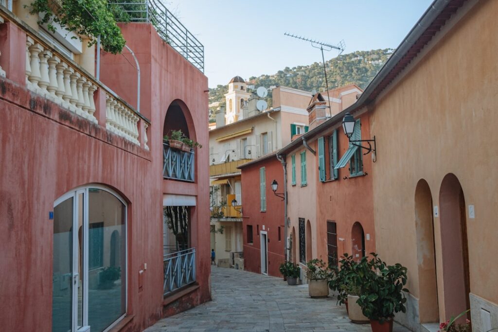 Narrow stone street lined with pastel buildings and potted plants in Capri