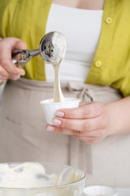 Mani che porzionano gelato cremoso in coppetta