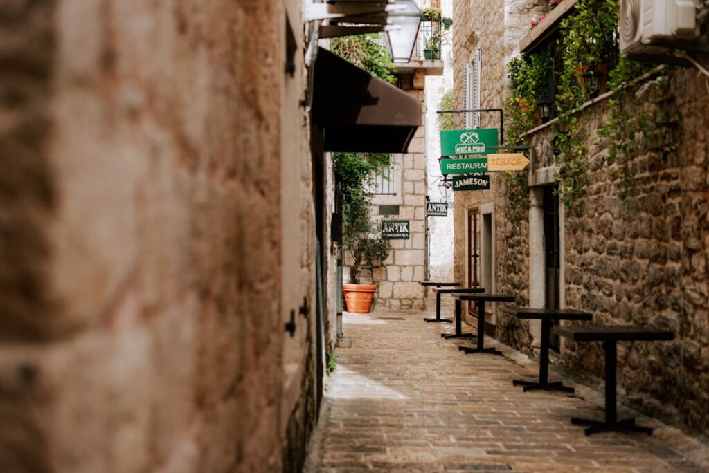 Enge Stein-Gasse in Capri mit geschlossenen Cafétischen und Schildern
