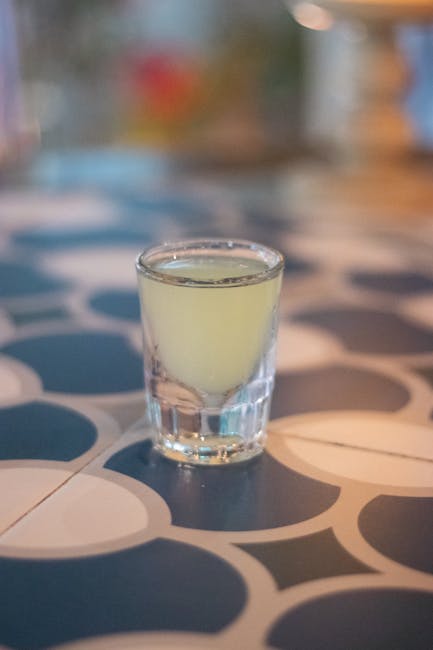Eiskaltes Limoncello im Schnapsglas auf Holztisch