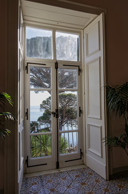 Open doors framing pine trees and sea views from a Capri room
