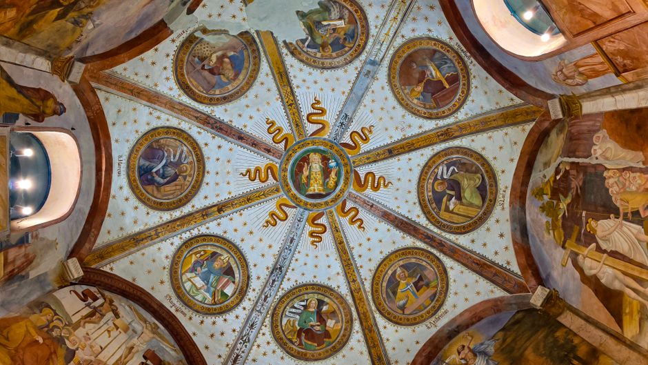Bemalte Kuppeldecke mit Heiligenkreis und goldenen Sternen in Capris Kirche
