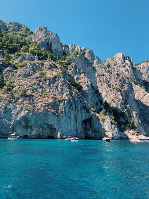 Steile Klippen und Meeresgrotten mit kleinen Booten vor Capri.