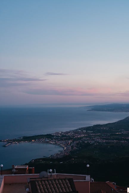Vue panoramique sur la baie sicilienne et la côte au crépuscule.