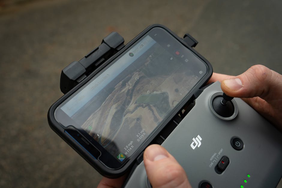 Mani su telecomando DJI con smartphone che mostra mappa di volo in Sicilia