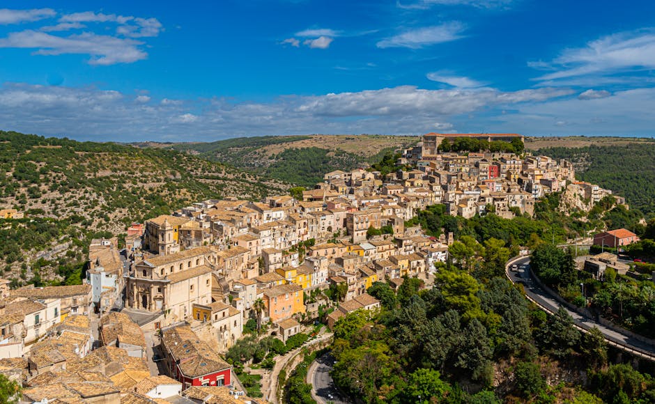 Sunlit hilltop Sicilian town with terracotta roofs and winding roads