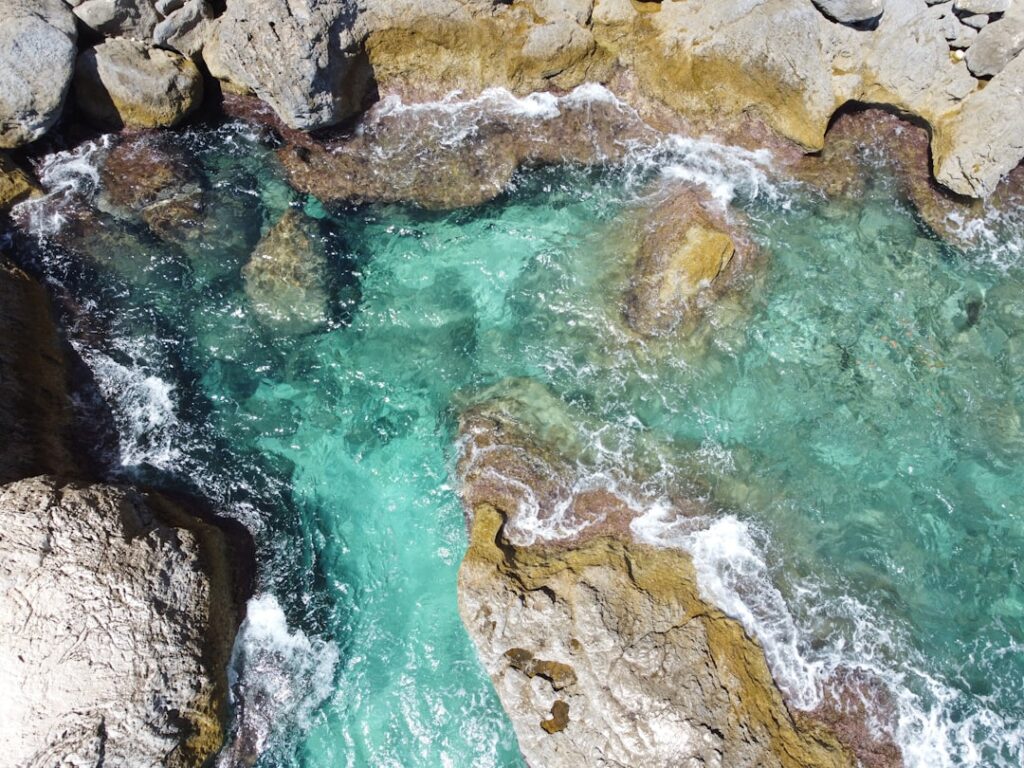 Eaux turquoise claires léchant des rochers calcaires sur côte sicilienne