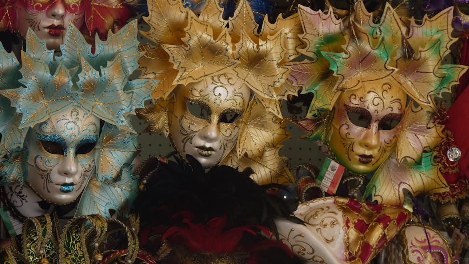 Golden and turquoise leaf-adorned carnival masks displayed in Sicilian shop