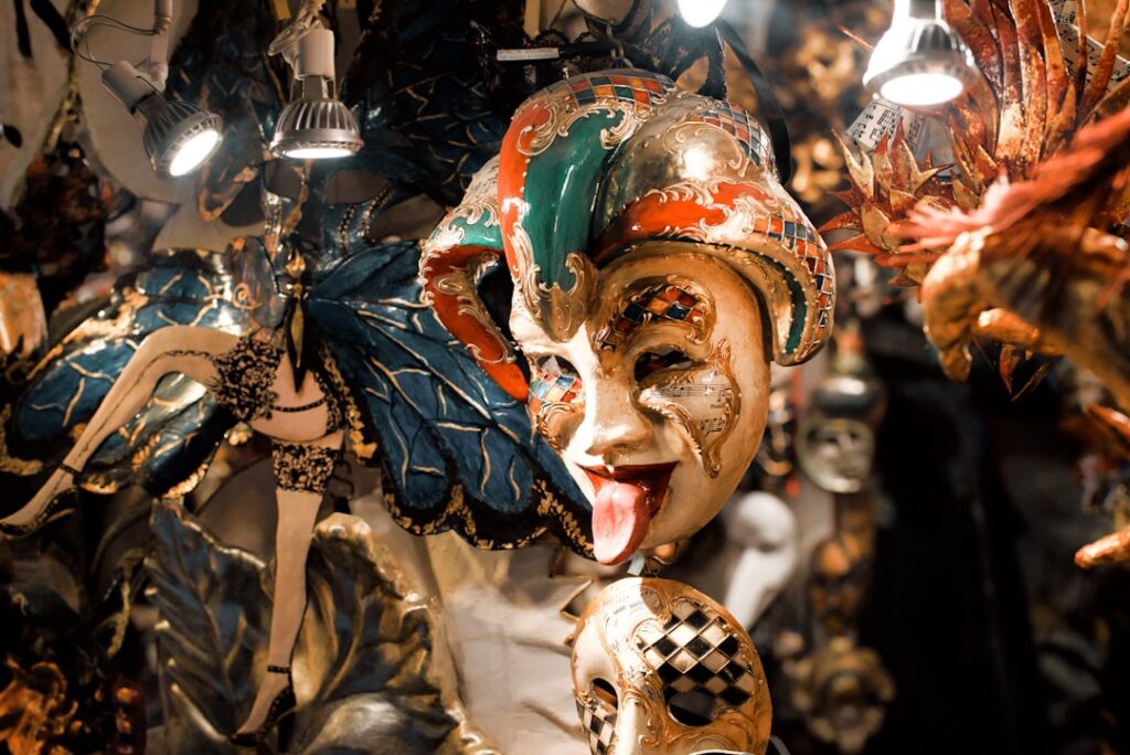 Playful jester mask sticking tongue out among ornate Sicilian masks