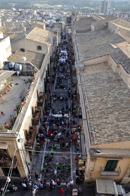 Rue étroite de Noto, Sicile, couverte de tapis et passants