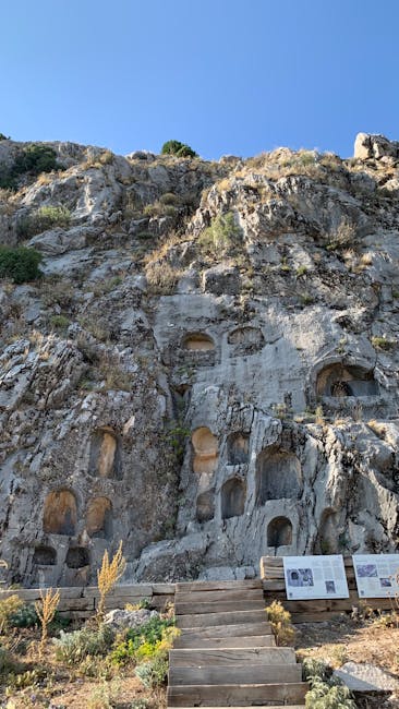 Falaise percée de niches funéraires anciennes avec escaliers d'accès, Sicile